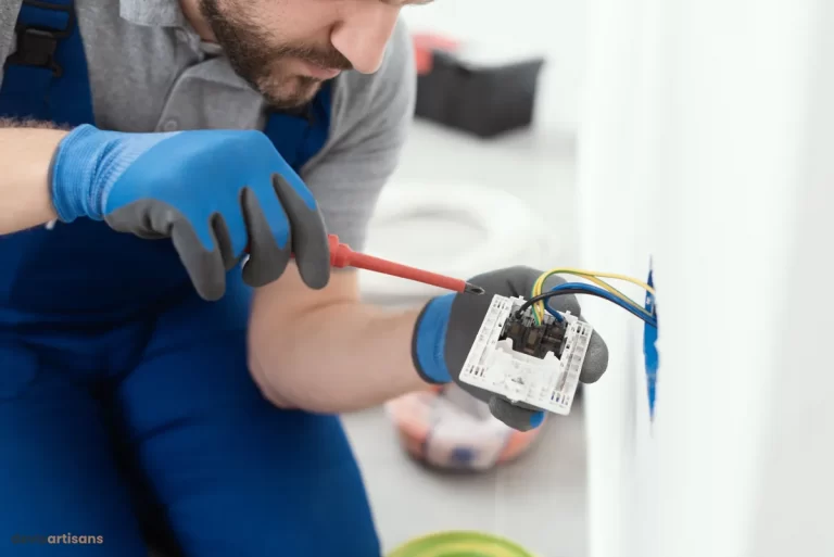 Un électricien travaillant sur une prise électrique.