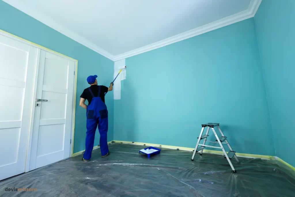 Un artisan peintre travaille sur un mur.